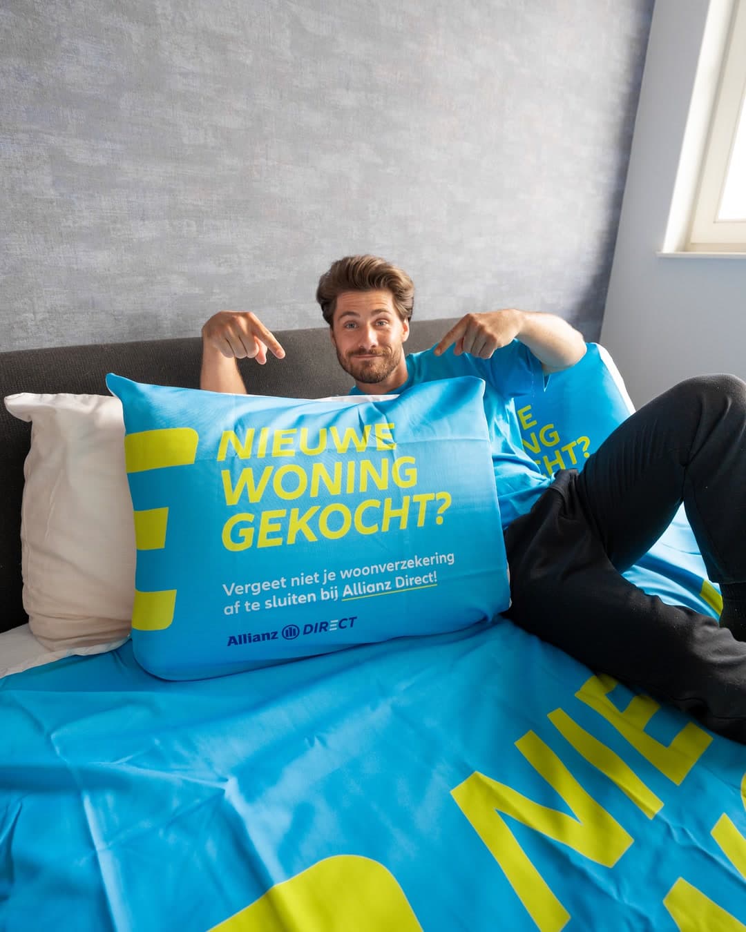 A man in bed pointing at an Allianz Direct pillow: bought a new home?